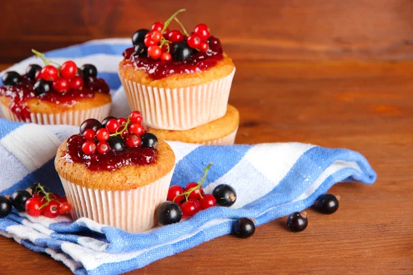 Smakelijke muffins met bessen op houten tafel — Stockfoto