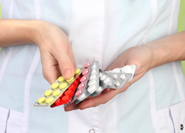 Close-up of female doctor hand holding pills, on color background — Stock Photo, Image
