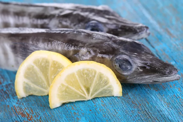 Fish with lemon on blue wooden table — Stock Photo, Image