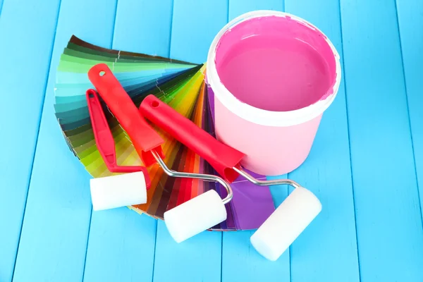 Conjunto para pintura: vasos de tinta, rolo de tinta na mesa de madeira azul — Fotografia de Stock