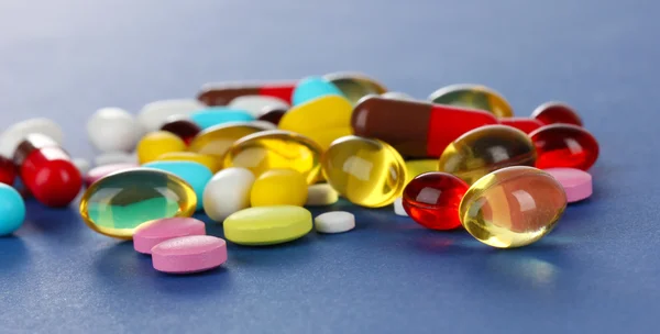 Assortiment van pillen, tabletten en capsules op blauwe achtergrond — Stockfoto