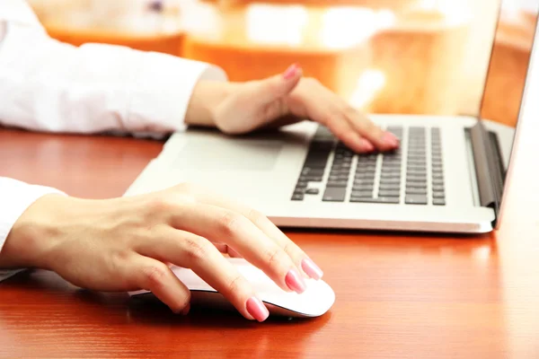 Mãos femininas trabalhando no laptop, no fundo brilhante — Fotografia de Stock