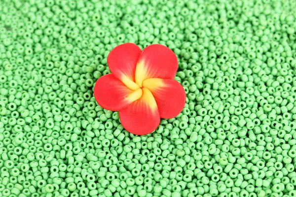 Зелений бісер з декоративною квіткою ручної роботи крупним планом — стокове фото
