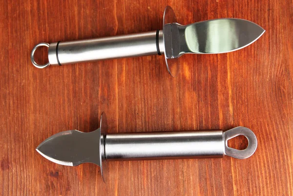 Knives for parmesan cheese and oysters, on wooden background — Stock Photo, Image