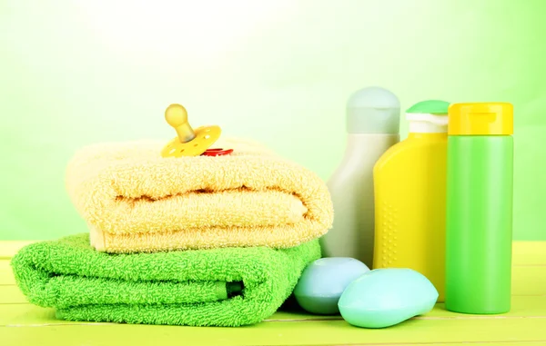 아기 화장품, 비누, 수건 녹색 배경에 나무 테이블에 — 스톡 사진
