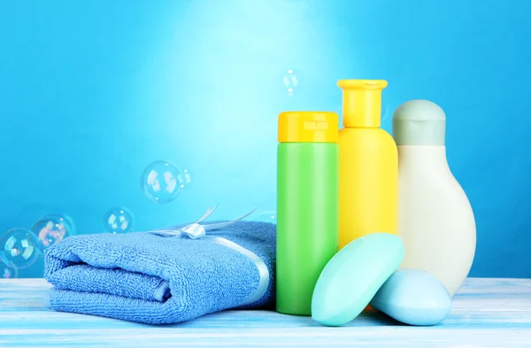 Cosméticos para bebés, toalla y jabón sobre mesa de madera, sobre fondo azul —  Fotos de Stock