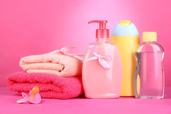 Baby cosmetics and towels on pink background — Stock Photo, Image