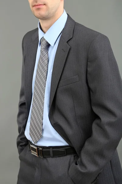 Giovane uomo d'affari su sfondo grigio — Foto Stock