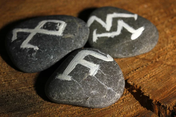 Fortune telling with symbols on stones on wooden background — Stock Photo, Image