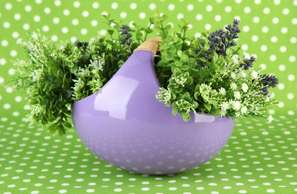 Pot with flowers on a green fabric background — Stock Photo, Image