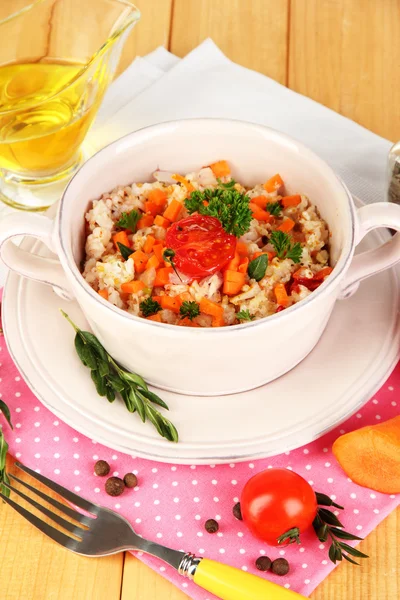 Delicioso arroz con verduras y hierbas en maceta sobre mesa de madera de cerca —  Fotos de Stock