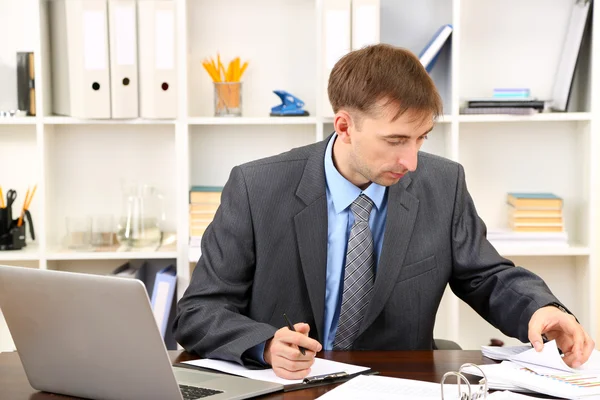 Jovem empresário no escritório em seu local de trabalho — Fotografia de Stock