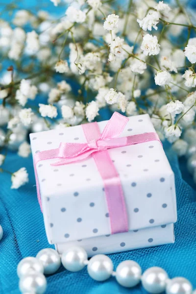 Bloemen en cadeau op blauw doek — Stockfoto