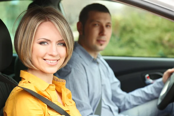 Portrait of young beautiful couple sitting in the car — Stock Photo, Image