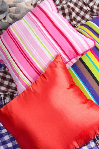 Tre cuscini vari lucenti su plaid — Foto Stock