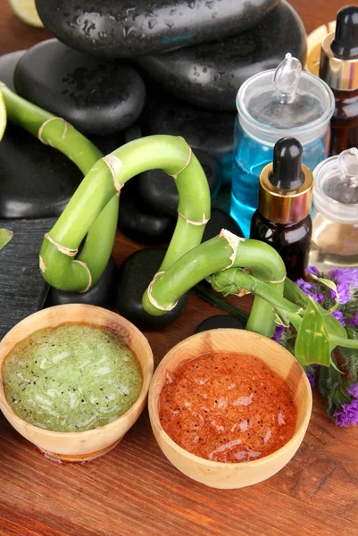 Spas composition with oils and spa stones on wooden table close-up — Stock Photo, Image