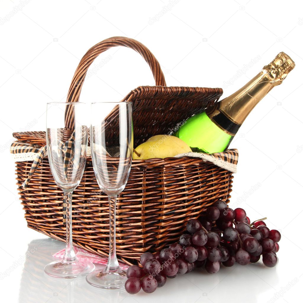 Picnic basket with fruits and bottle of champagne isolated on white