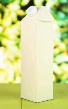 Tablo parlak zemin üzerine süt paketi