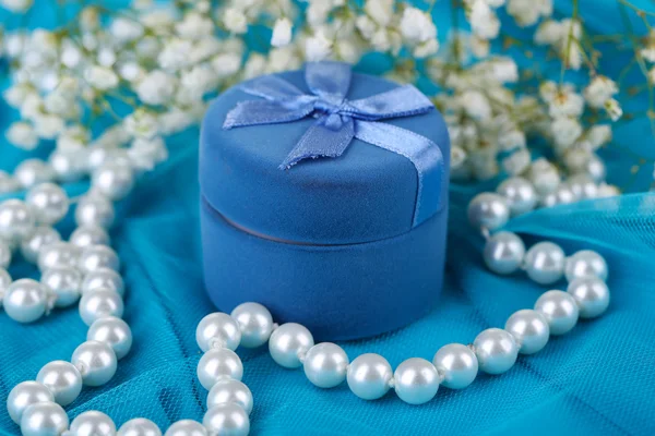 Fleurs et bague de fiançailles sur tissu bleu — Photo