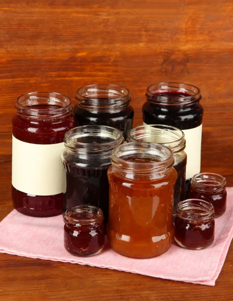 Tasty jam in banks on wooden background — Stock Photo, Image