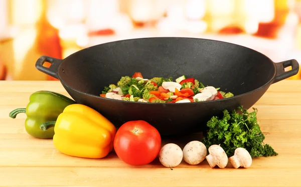 Wok med grönsaker ragu på träbord, på ljus bakgrund — Stockfoto