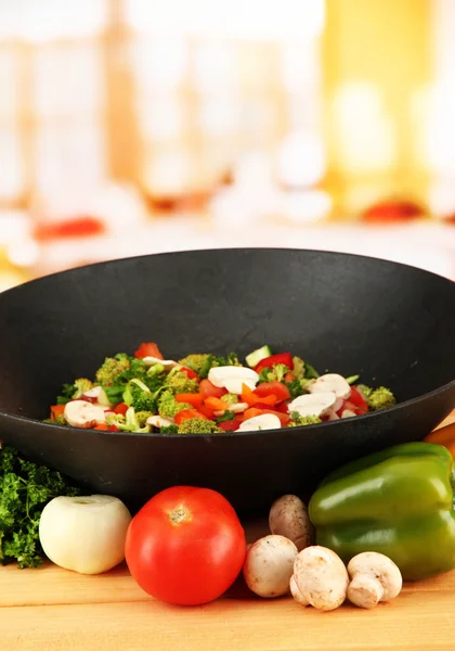 Wok med grönsaker ragu på träbord, på ljus bakgrund — Stockfoto