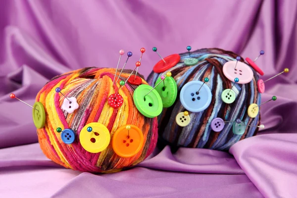 Colorful buttons and multicolor wool balls, on color fabric background — Stock Photo, Image