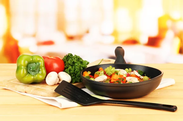Gemüseragout in der Pfanne, auf Holztisch auf hellem Hintergrund — Stockfoto