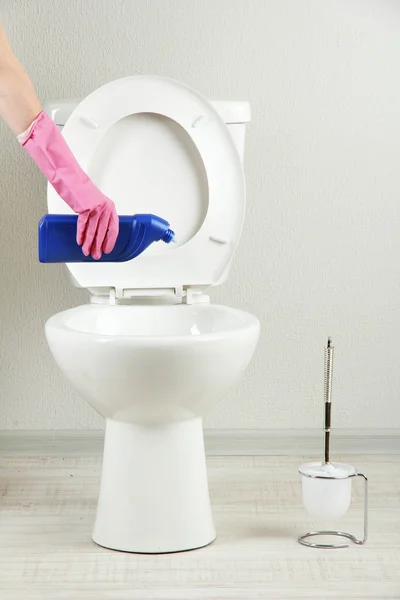Frau Hand mit Sprühflasche reinigt Toilettenschüssel im Badezimmer — Stockfoto