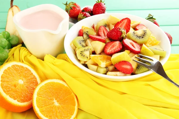 La ensalada útil de frutas frescas y las bayas en la escudilla a la servilleta a la mesa de madera el primer plano — Foto de Stock