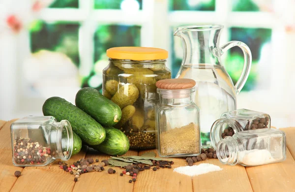 Tasty fresh and canned cucumbers, on wooden table on bright background — Stock Photo, Image