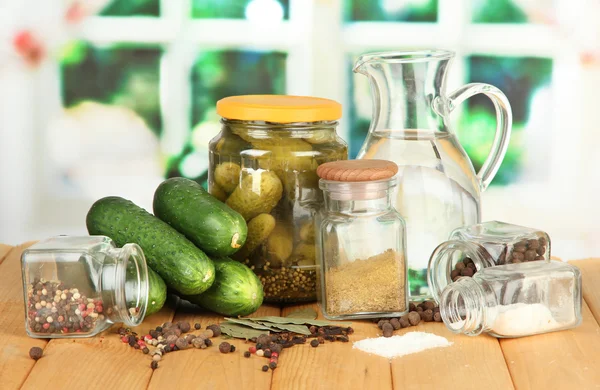 Schmackhafte frische und konservierte Gurken, auf Holztisch auf hellem Hintergrund — Stockfoto