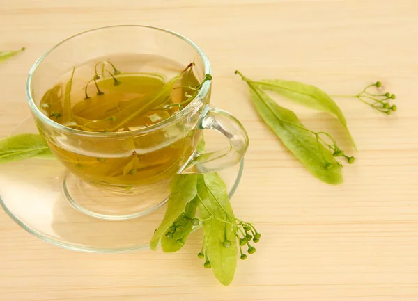 Glass cup of tea with linden on wooden table close-up — Stock Photo, Image