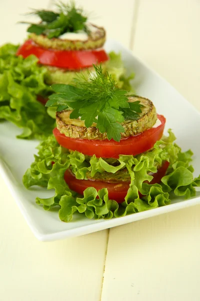 Leckere geröstete Knochenmark und Tomatenscheiben mit Salatblättern, auf Holzgrund — Stockfoto