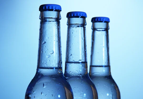 Láhve vody na modrém pozadí — Stock fotografie