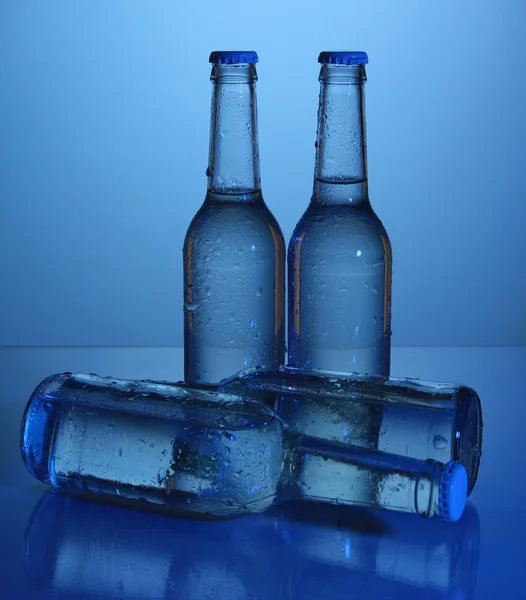 Botellas de agua sobre fondo azul —  Fotos de Stock