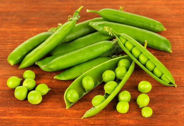 Guisantes verdes dulces sobre fondo de madera — Foto de Stock