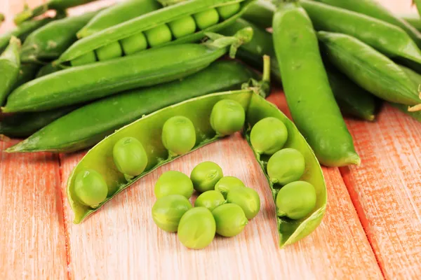 Guisantes verdes dulces sobre fondo de madera — Foto de Stock