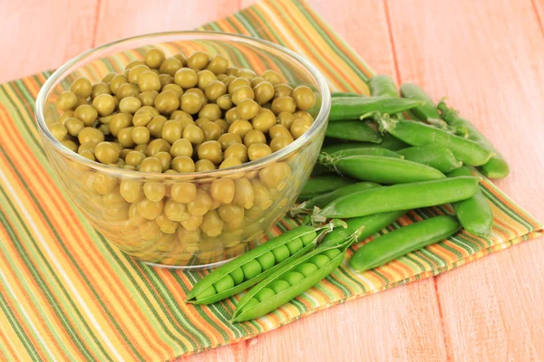 Guisantes verdes sobre fondo de madera — Foto de Stock