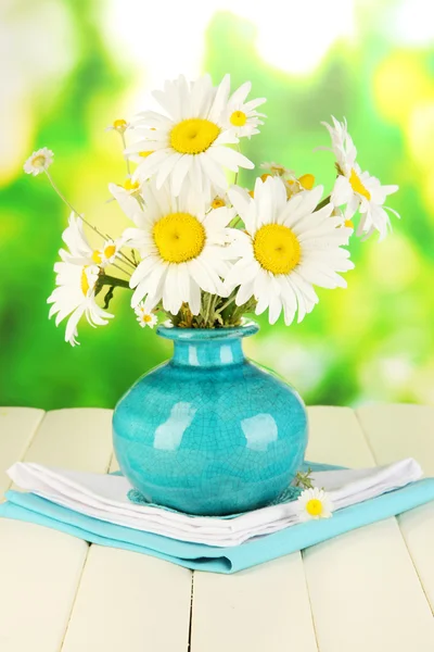 Beautiful bouquet chamomiles in vase on wooden table on natural background — Stock Photo, Image