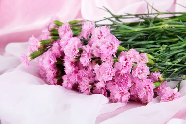 Muchos pequeños dientes de color rosa sobre fondo de tela clara — Foto de Stock