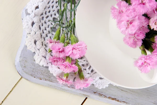 Nombreux petits clous de girofle roses en tasse sur planche en bois close-up — Photo