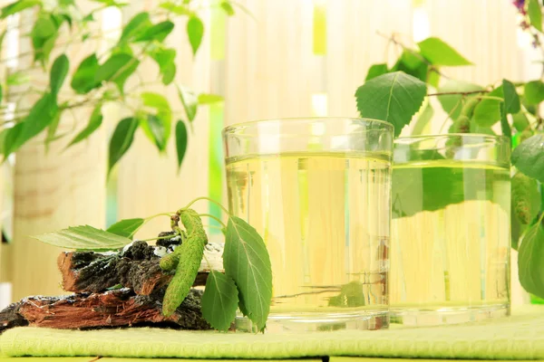 Glazen birch sap op groene houten tafel — Stockfoto