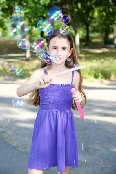 Mignonne fille souffler des bulles de savon à l'extérieur — Photo