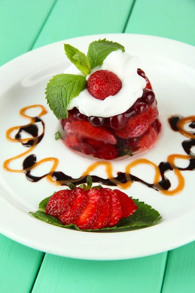 Tasty jelly dessert with fresh berries, on color wooden background — Stock Photo, Image