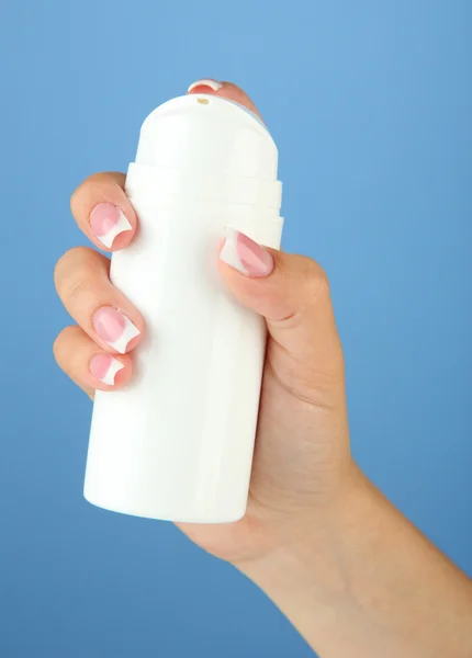 Bottiglia mano donna con crema su sfondo di colore — Foto Stock