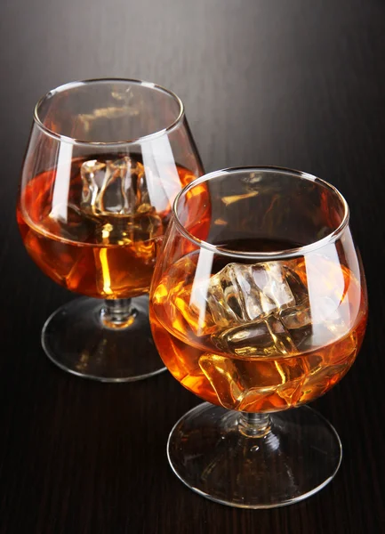 Verres Brandy avec glace sur fond en bois — Photo