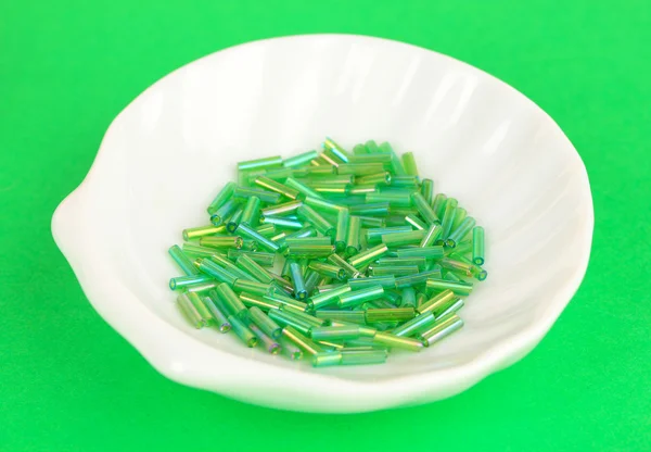Gröna pärlor på plattan på grön bakgrund — Stockfoto