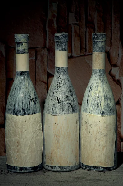 Old bottles of wine in old cellar, on dark background — Stock Photo, Image