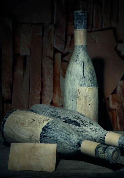 Vieilles bouteilles de vin dans une ancienne cave, sur fond sombre — Photo